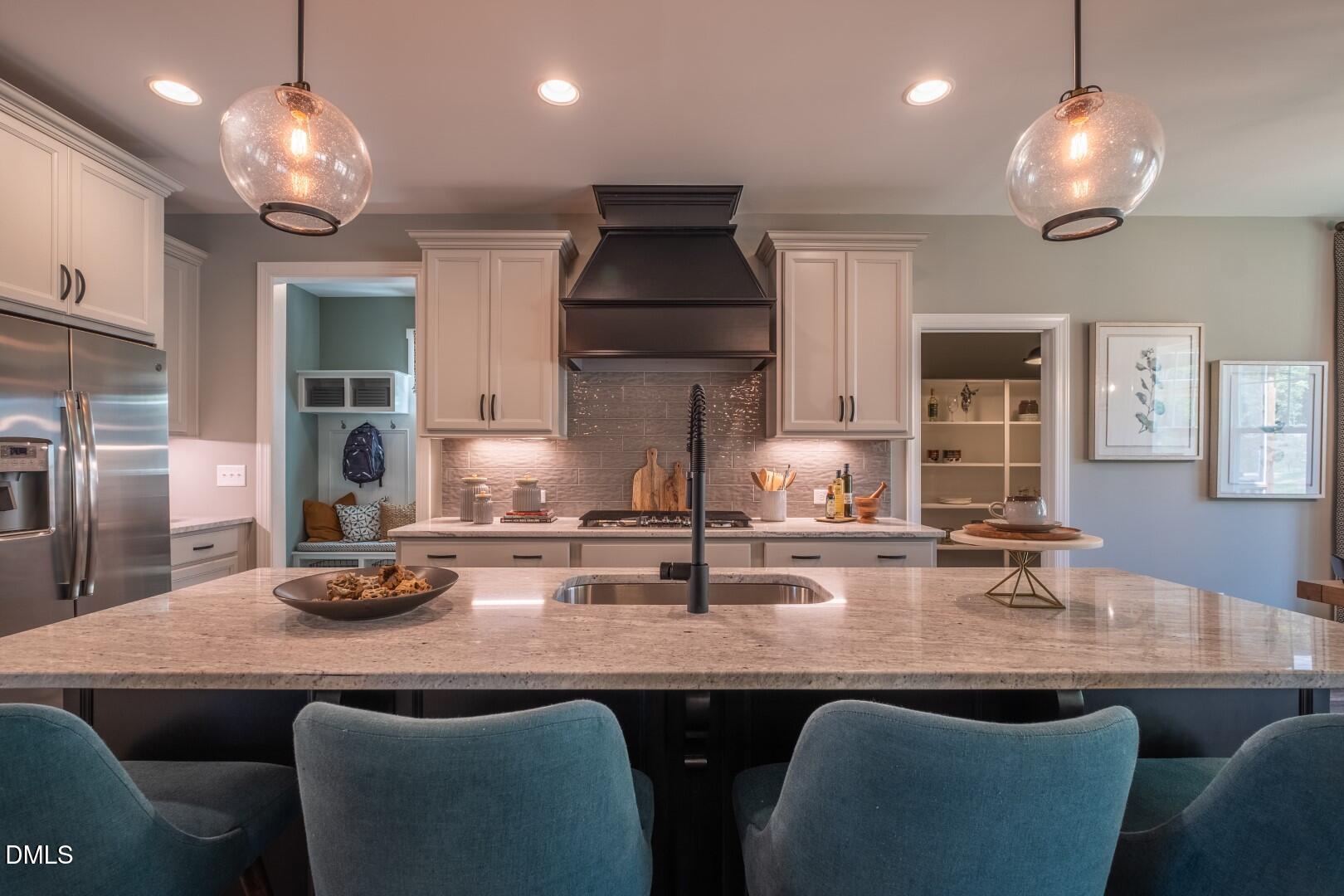 326 Oak Meadow Lane Angier, NC 27501 - Photo 13 of 41 a kitchen with stainless steel appliances granite countertop a dining table and chairs in it