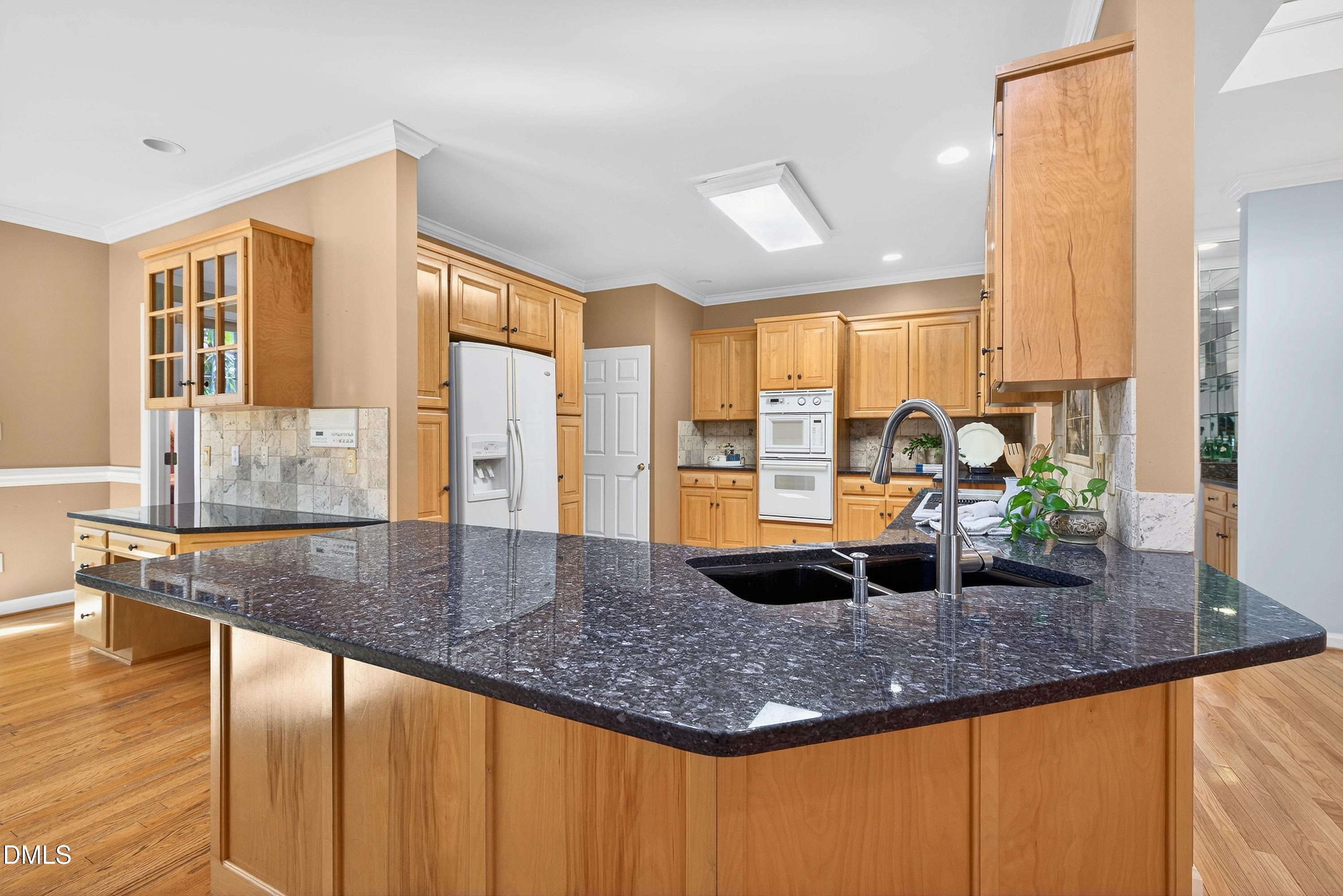 2217 Moss Point Lane Raleigh, NC 27606 - Photo 19 of 70 a kitchen with granite countertop a sink and a large window