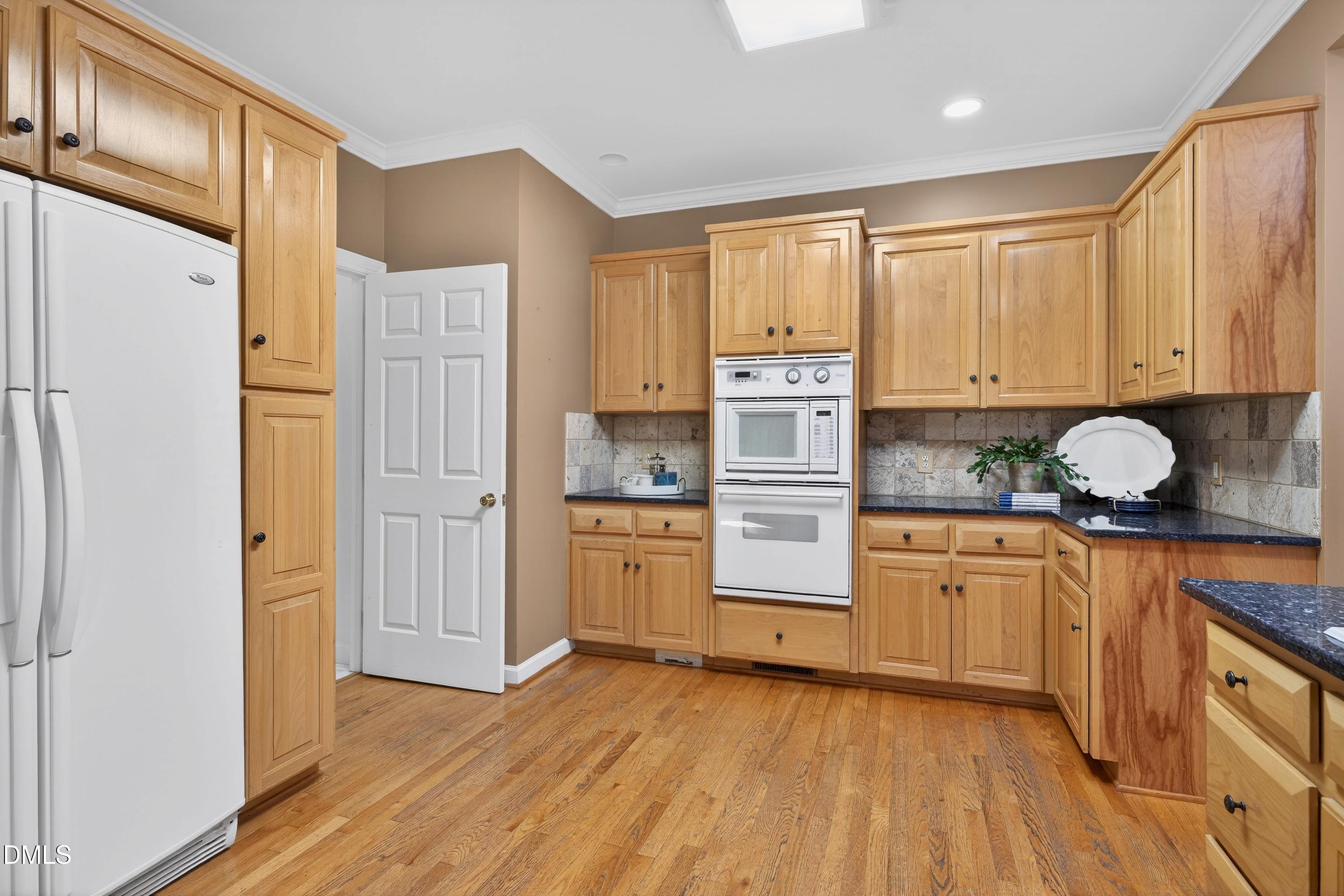 2217 Moss Point Lane Raleigh, NC 27606 - Photo 22 of 70 a kitchen with granite countertop a refrigerator sink and cabinets