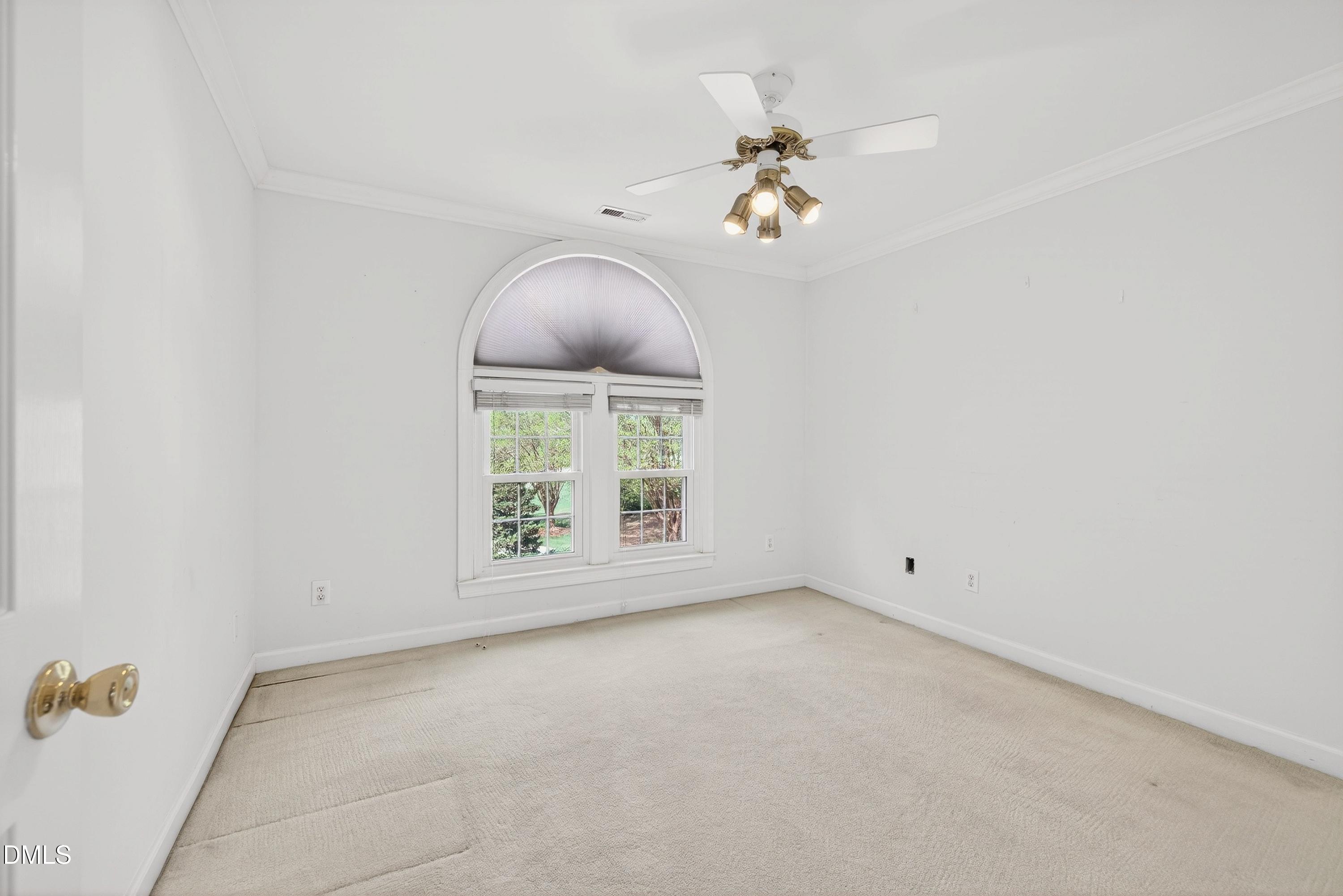 2217 Moss Point Lane Raleigh, NC 27606 - Photo 39 of 70 an empty room with a chandelier fan and windows