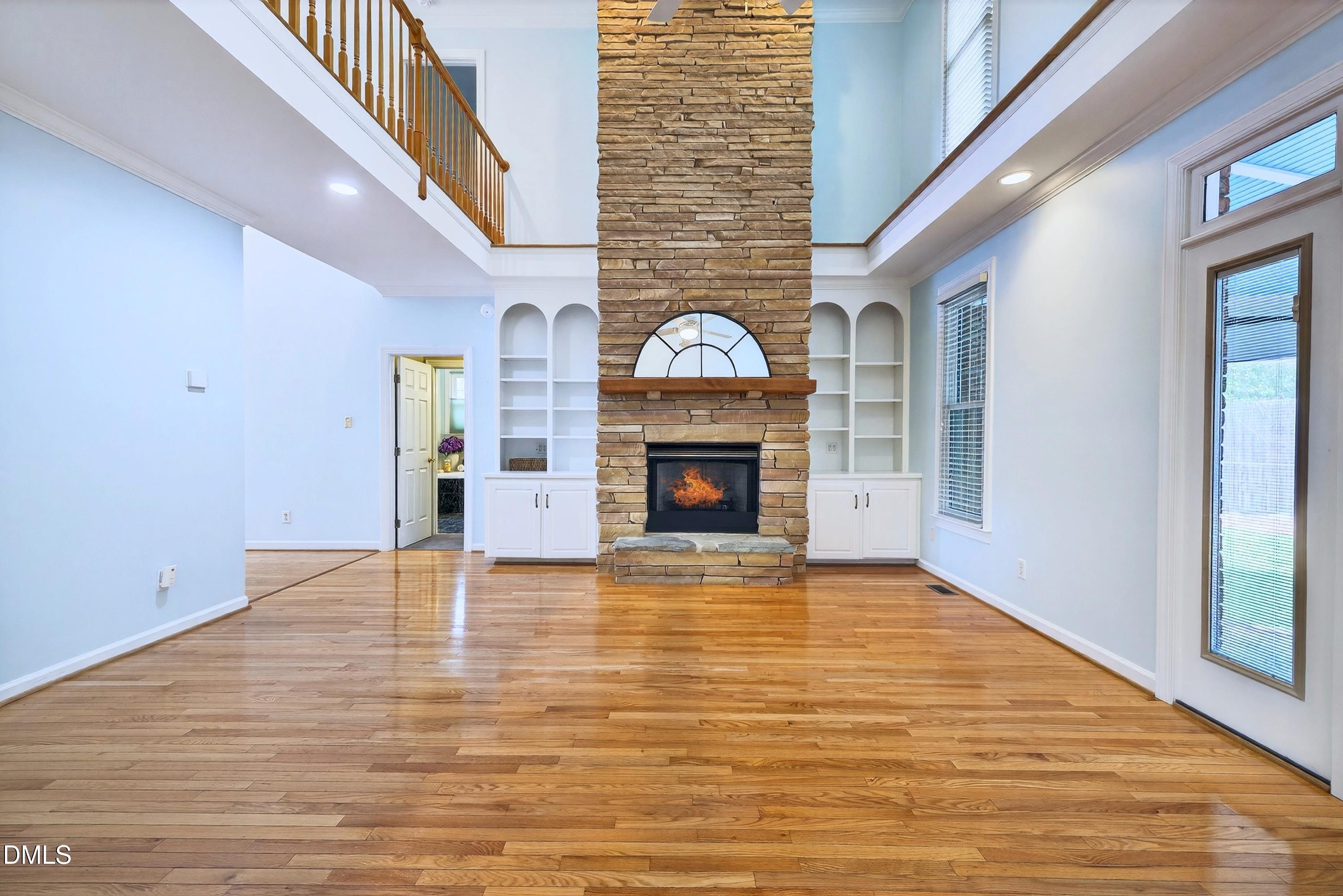 2217 Moss Point Lane Raleigh, NC 27606 - Photo 7 of 70 a view of an empty room with wooden floor fireplace and a window
