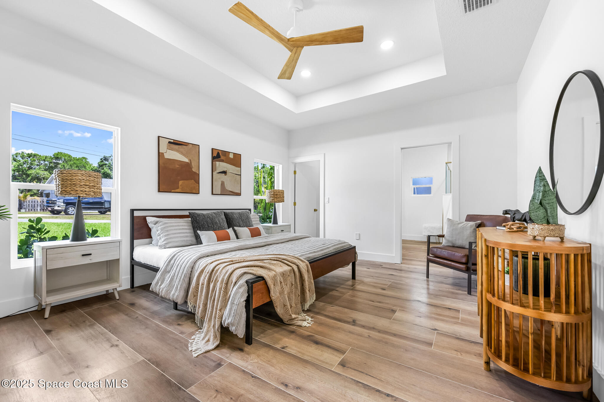 1313 Worth Court Northeast Palm Bay, FL 32905 - Photo 29 of 77 a spacious bedroom with a bed a couch and a window