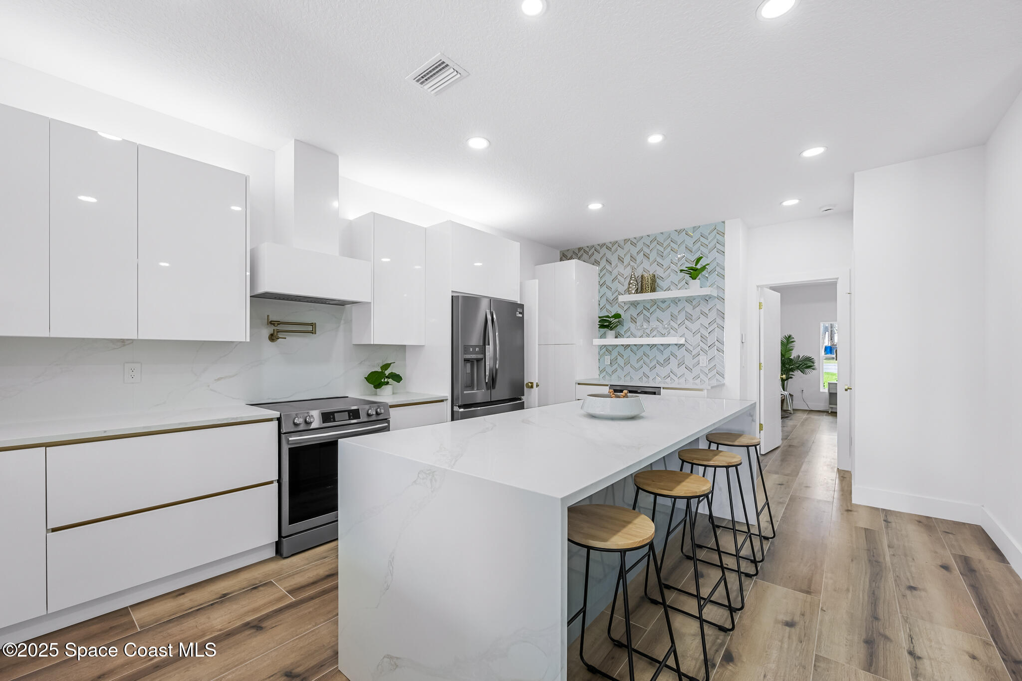 1313 Worth Court Northeast Palm Bay, FL 32905 - Photo 38 of 77 a kitchen with stainless steel appliances kitchen island a table and chairs in it