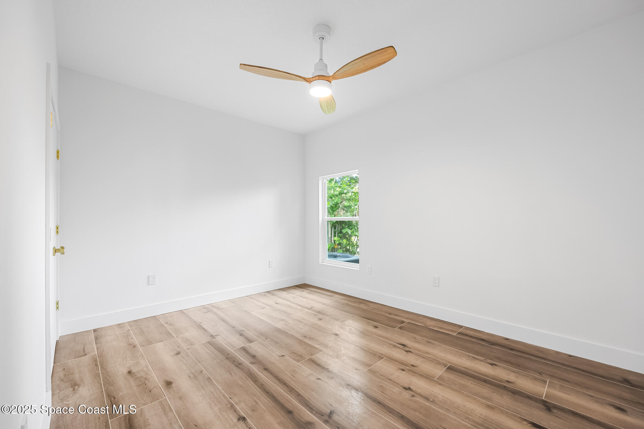 1313 Worth Court Northeast Palm Bay, FL 32905 - Photo 43 of 77 an empty room with a window and a ceiling fan