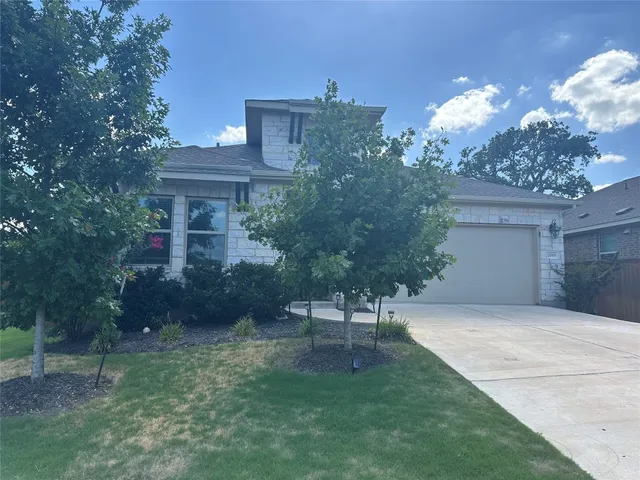 a view of a house with a yard and a garden