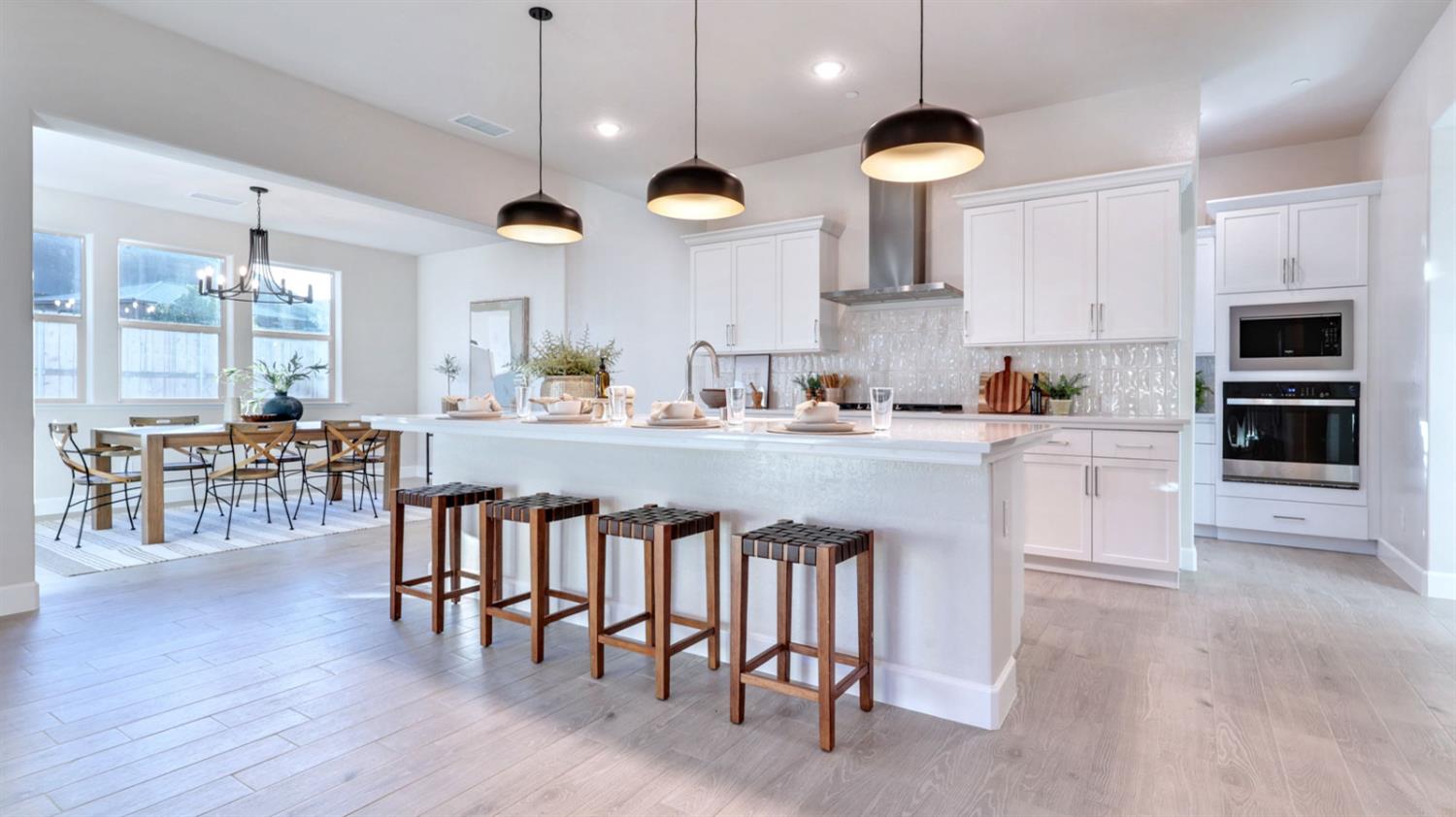 951 Talus Way South Madera, CA 93636 - Photo 7 of 36 a kitchen with stainless steel appliances a dining table chairs sink and stove top oven