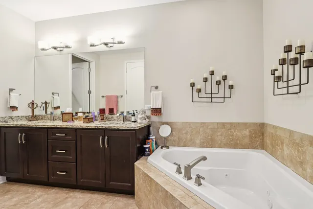 a bathroom with a tub sink and mirror