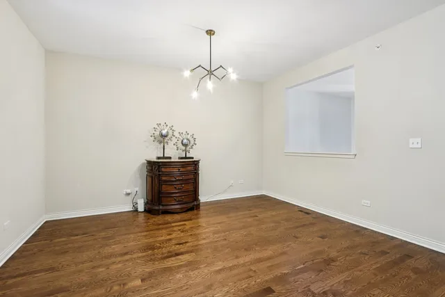 a view of empty room with wooden floor and ceiling fan