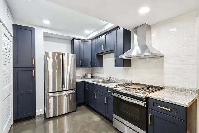 a kitchen with stainless steel appliances granite countertop a stove a refrigerator and a sink