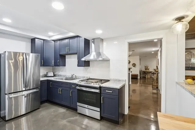 a kitchen with stainless steel appliances granite countertop a stove sink and refrigerator