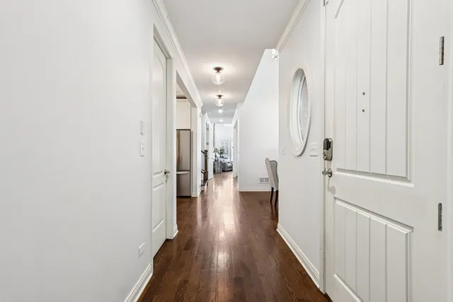a view of a hallway with wooden floor and staircase