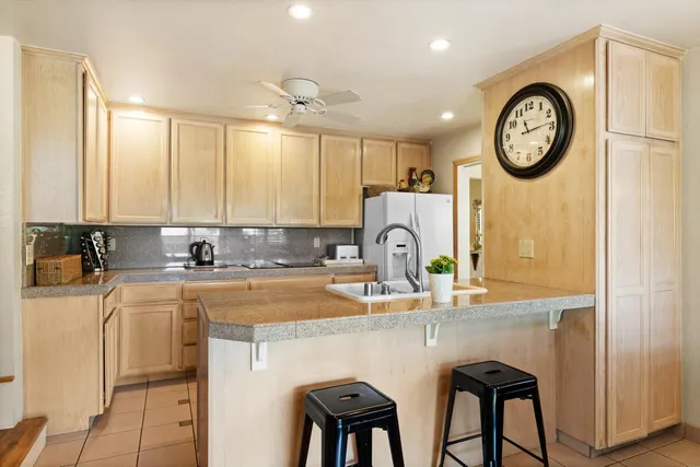 a kitchen with stainless steel appliances a table chairs and a refrigerator