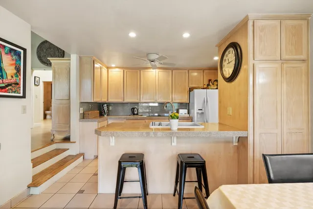 a kitchen with stainless steel appliances granite countertop a stove a refrigerator and a sink with cabinets