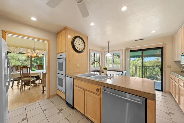 a kitchen with kitchen island granite countertop a sink a counter top space appliances and cabinets