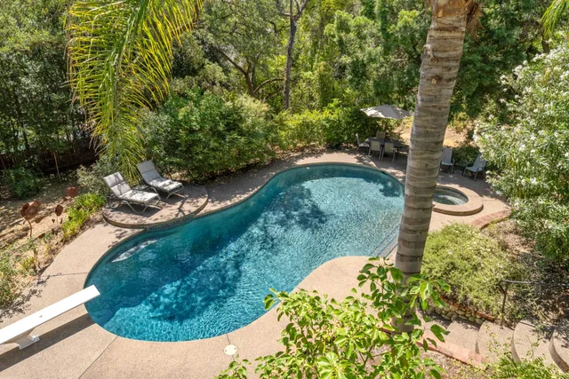 an aerial view of residential house with outdoor space and trees all around