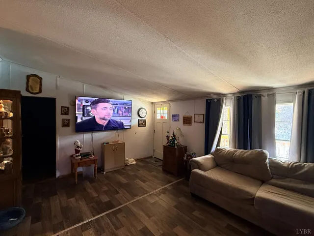 a living room with furniture a window and a flat screen tv