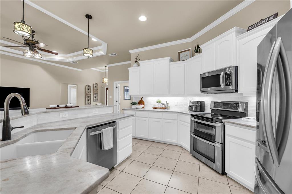 910 Springdale Lane Lorena, TX 76655 - Photo 8 of 39 Contemporary kitchen featuring white cabinetry, light-toned countertops, and stainless steel appliances