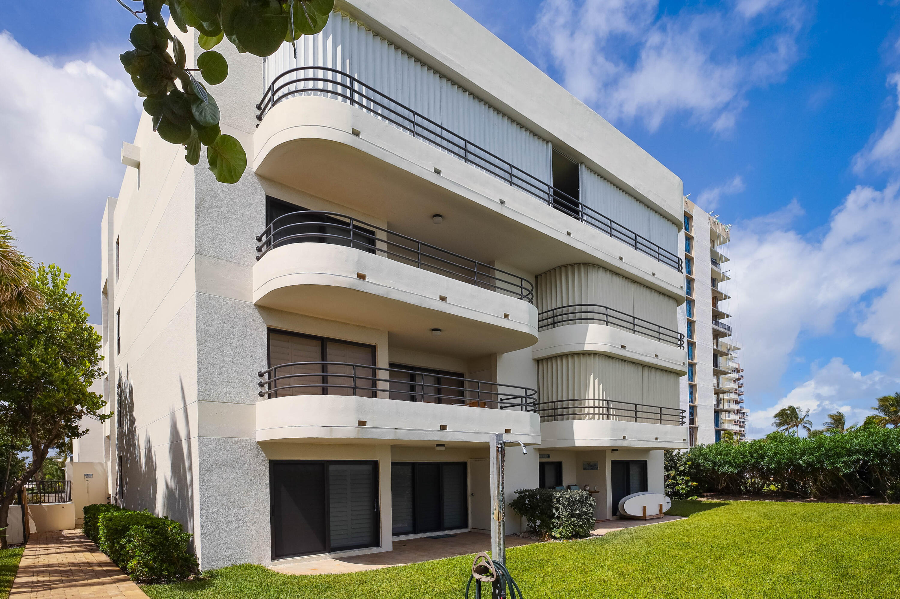 420 Celestial Way, Unit 204 Juno Beach, FL 33408 - Photo 29 of 35 a front view of a building with a garden and plants