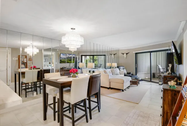 a living room with furniture a flat screen tv and a floor to ceiling window