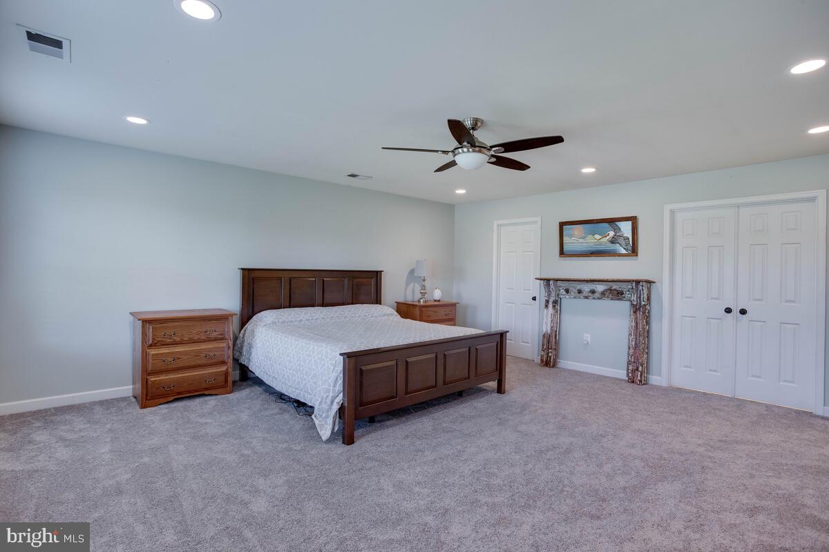 3369 Evans Road Huntingtown, MD 20639 - Photo 34 of 59 a spacious bedroom with a bed and a ceiling fan