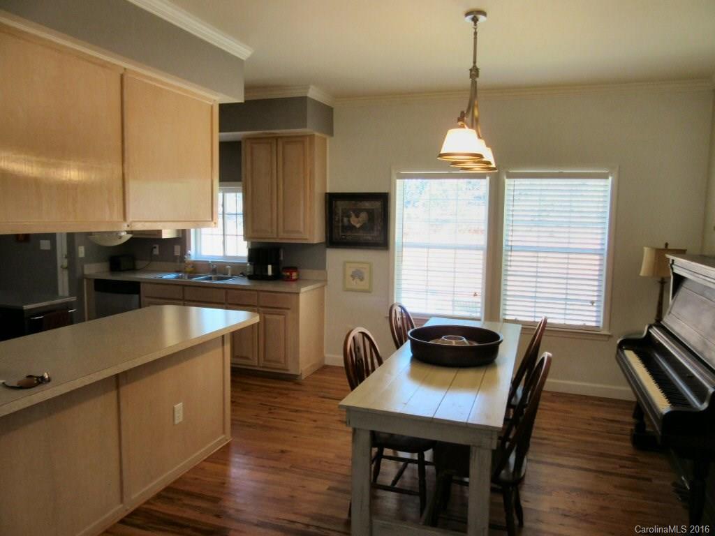 115 Coltons Way, Unit 2 Penrose, NC 28766 - Photo 5 of 14 a kitchen with sink refrigerator dining table and chairs