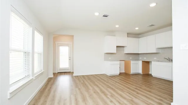 a view of a kitchen with wooden floor and a window