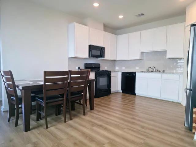 a view of kitchen with cabinets table and chairs