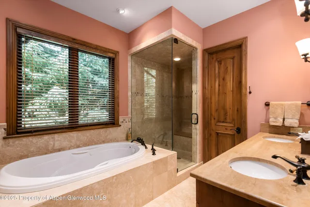 a bathroom with a tub sink and mirror
