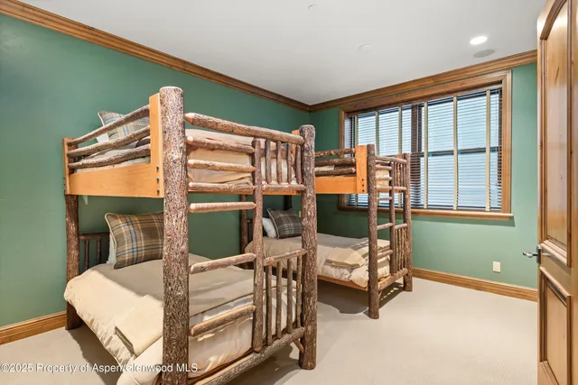 a bedroom with a bunk bed and a window