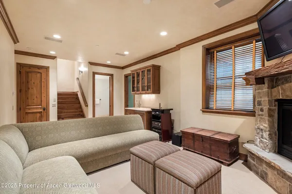 a living room with stainless steel appliances granite countertop furniture and a fireplace