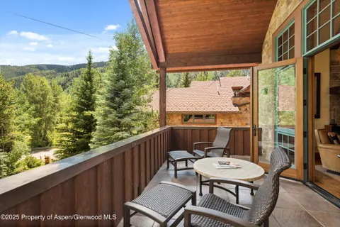 a living room with furniture a fireplace and floor to ceiling windows