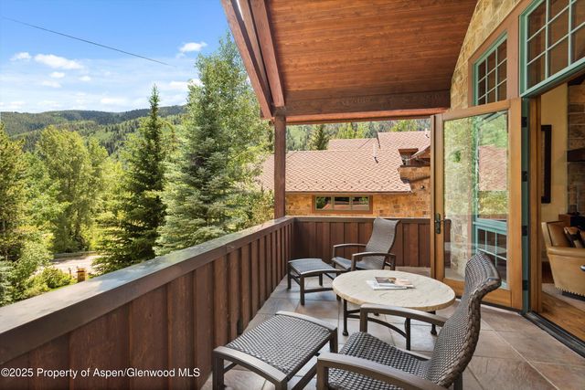 a living room with furniture a fireplace and floor to ceiling windows