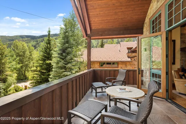 a living room with furniture a fireplace and floor to ceiling windows