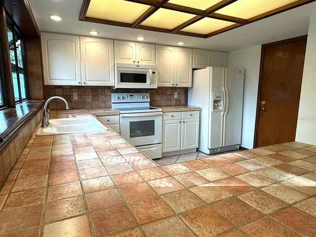a kitchen with stainless steel appliances a stove a sink cabinets and a refrigerator