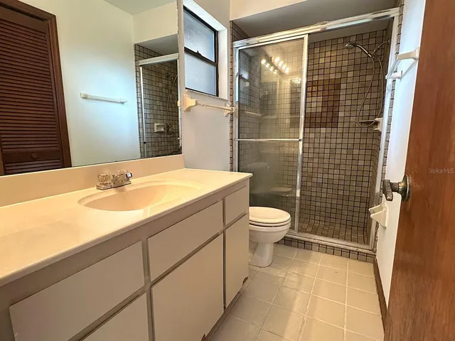 a bathroom with a granite countertop toilet and a shower