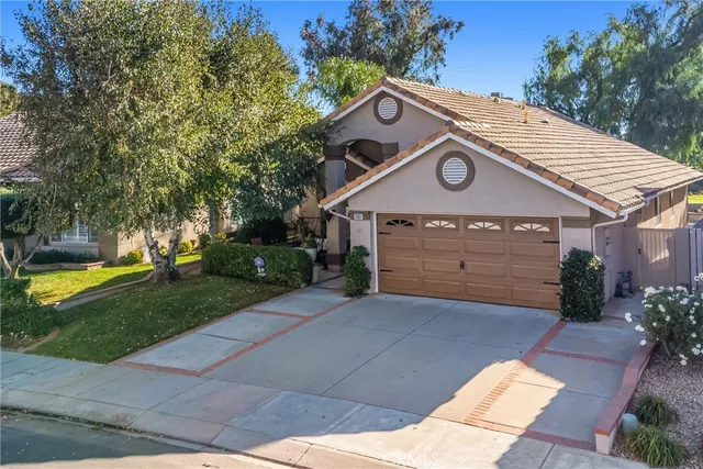 a view of a house with a yard and large tree