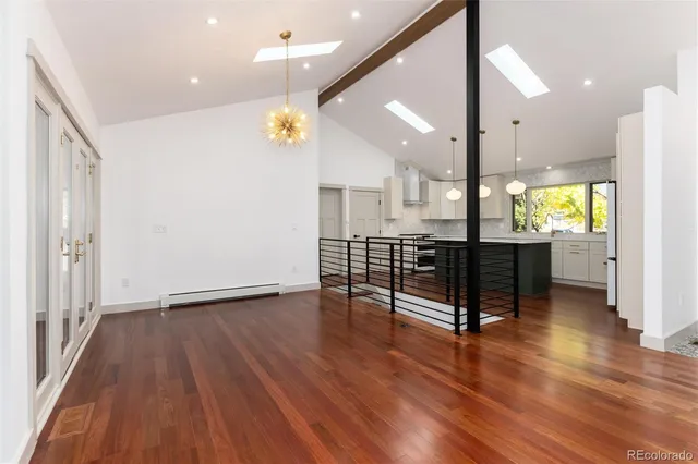 a view of an empty room with glass door and wooden floor