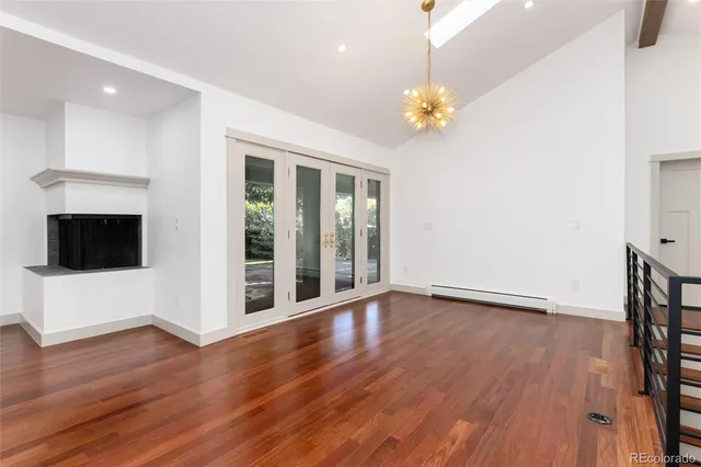 a view of a big room with wooden floor and windows
