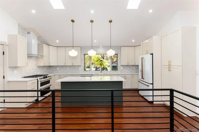 a kitchen with kitchen island a sink stove and wooden floor