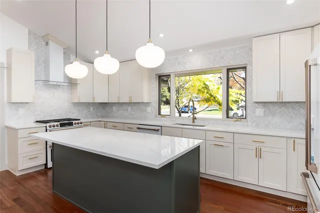 a kitchen with stainless steel appliances white cabinets and a window