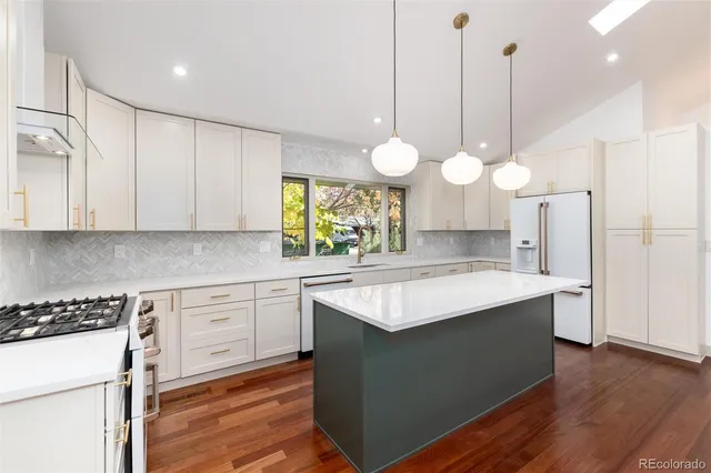 a kitchen with a chandelier stainless steel appliances cabinets and a counter top space