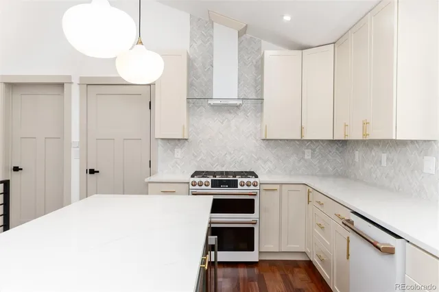 a kitchen with a stove a sink a center island and wooden floor