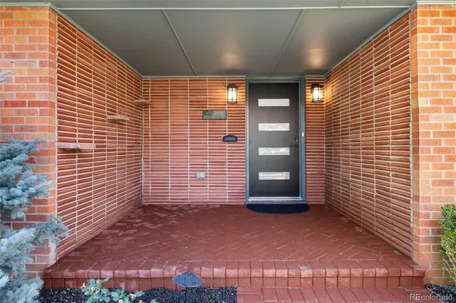 a view of a hallway with wooden floor and a kitchen