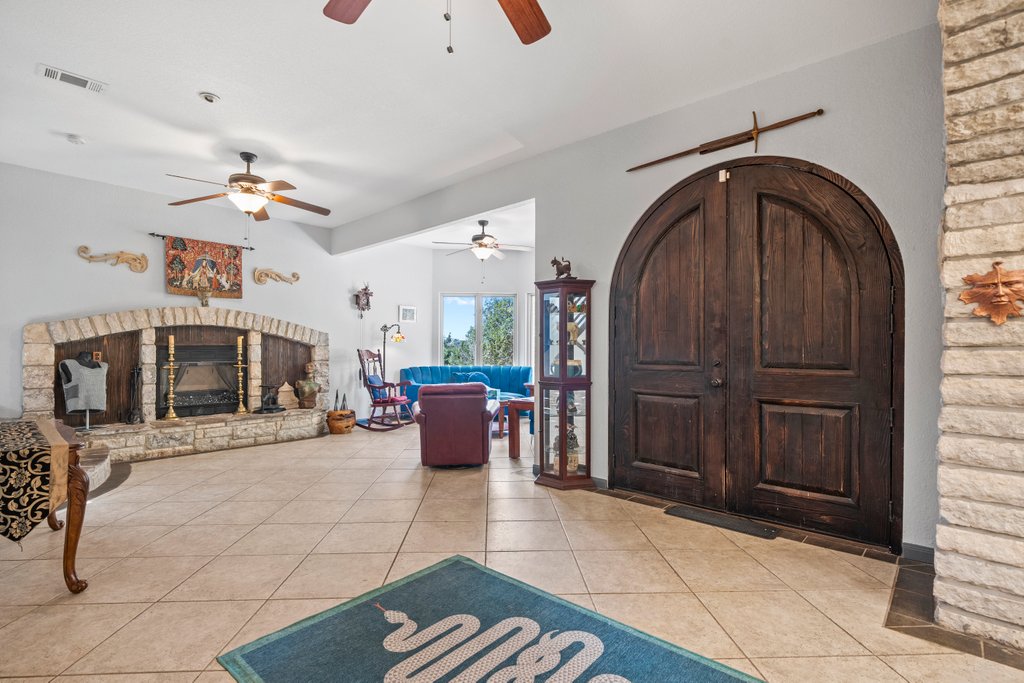 209 Lakeview Circle Spring Branch, TX 78070 - Photo 4 of 40 Entrance foyer with visible vents, a fireplace with raised hearth, and light tile patterned flooring