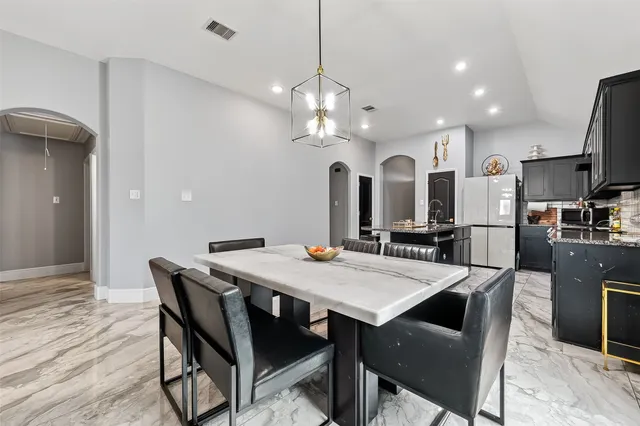 a view of a dining room with furniture and a chandelier