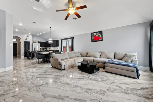 a living room with furniture and a ceiling fan