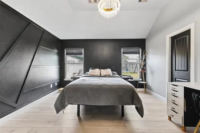 a bedroom with a bed and a flat tv screen on a dresser