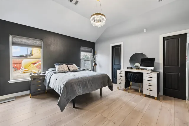 a bedroom with a bed and a chandelier