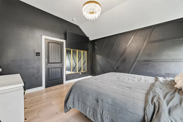 a bedroom with a bed and a chandelier