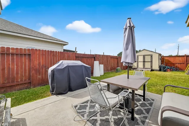 a view of a patio with table and chairs with wooden fence
